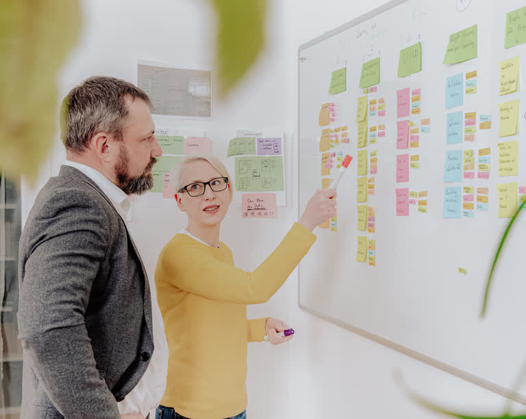 Eva berät einen Kunden am Whiteboard